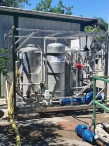 Impianto industriale di trattamento acque Etica montato su struttura metallica all'aperto con pompe e serbatoi in acciaio.