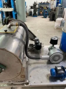 Macchinario industriale in acciaio inox utilizzato per attività di ricerca e sviluppo in laboratorio.