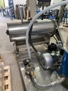 Macchinario industriale in acciaio inox con pompe e tubazioni per processi di ricerca e innovazione tecnologica.