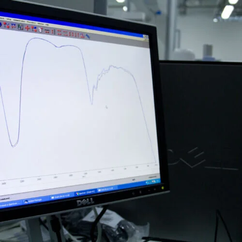 Monitor di un computer che mostra un grafico di spettroscopia infrarossa con curve di analisi chimica.